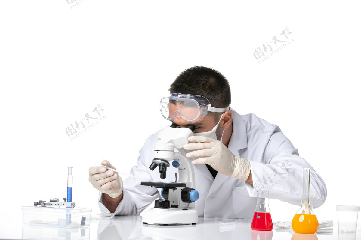 到期前视图：男医生穿着白色医疗服 戴着面罩 在空白处使用显微镜观察视图男人工作