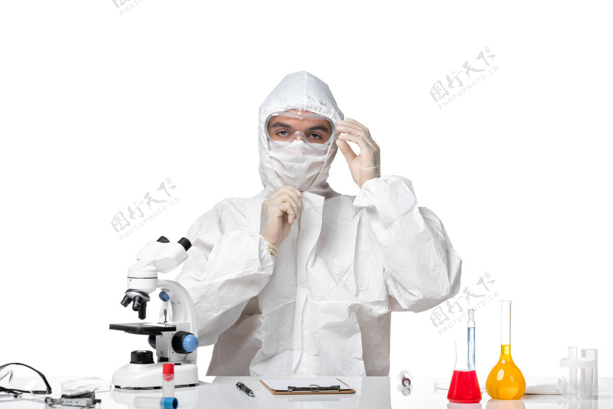 面具正面图：男医生穿着防护服 戴着面具 因为科维德坐在白色空间里坐着医疗实验室外套