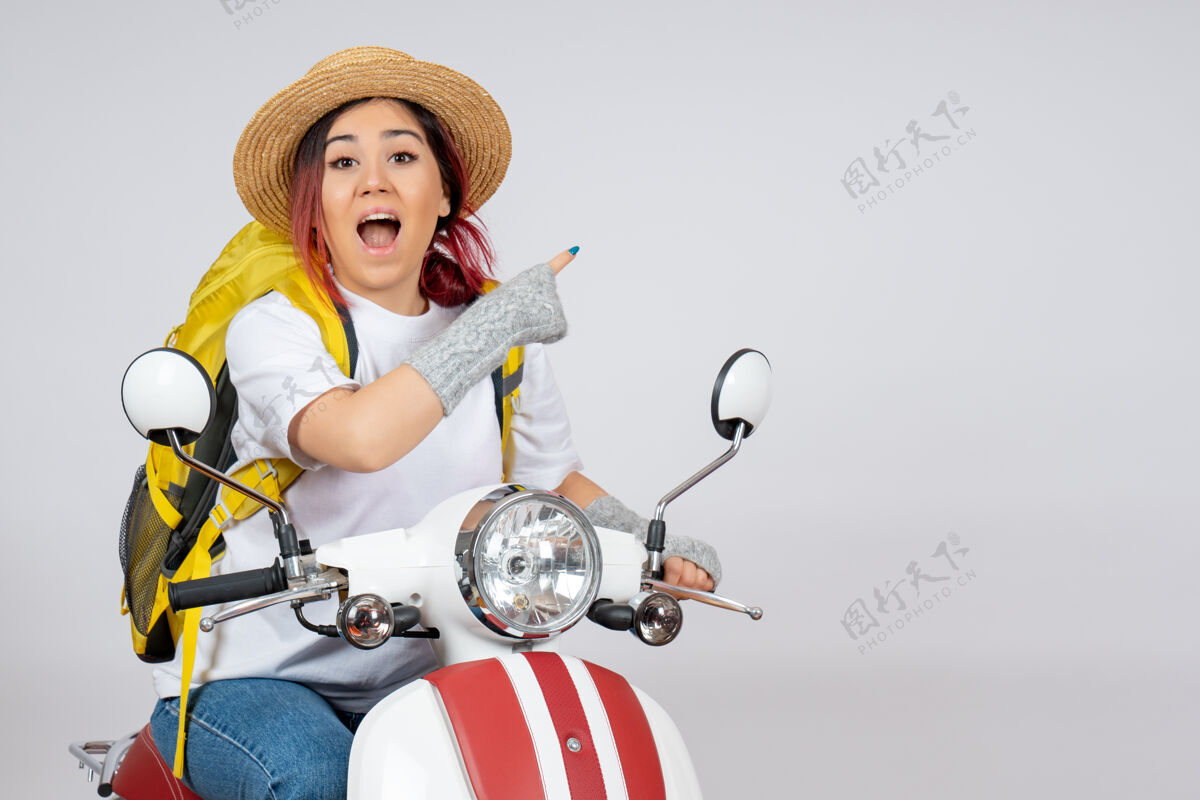 风景正面图年轻的女游客骑摩托车坐在白墙上的车上 女游客超速拍照乘车男人骑摩托车成人