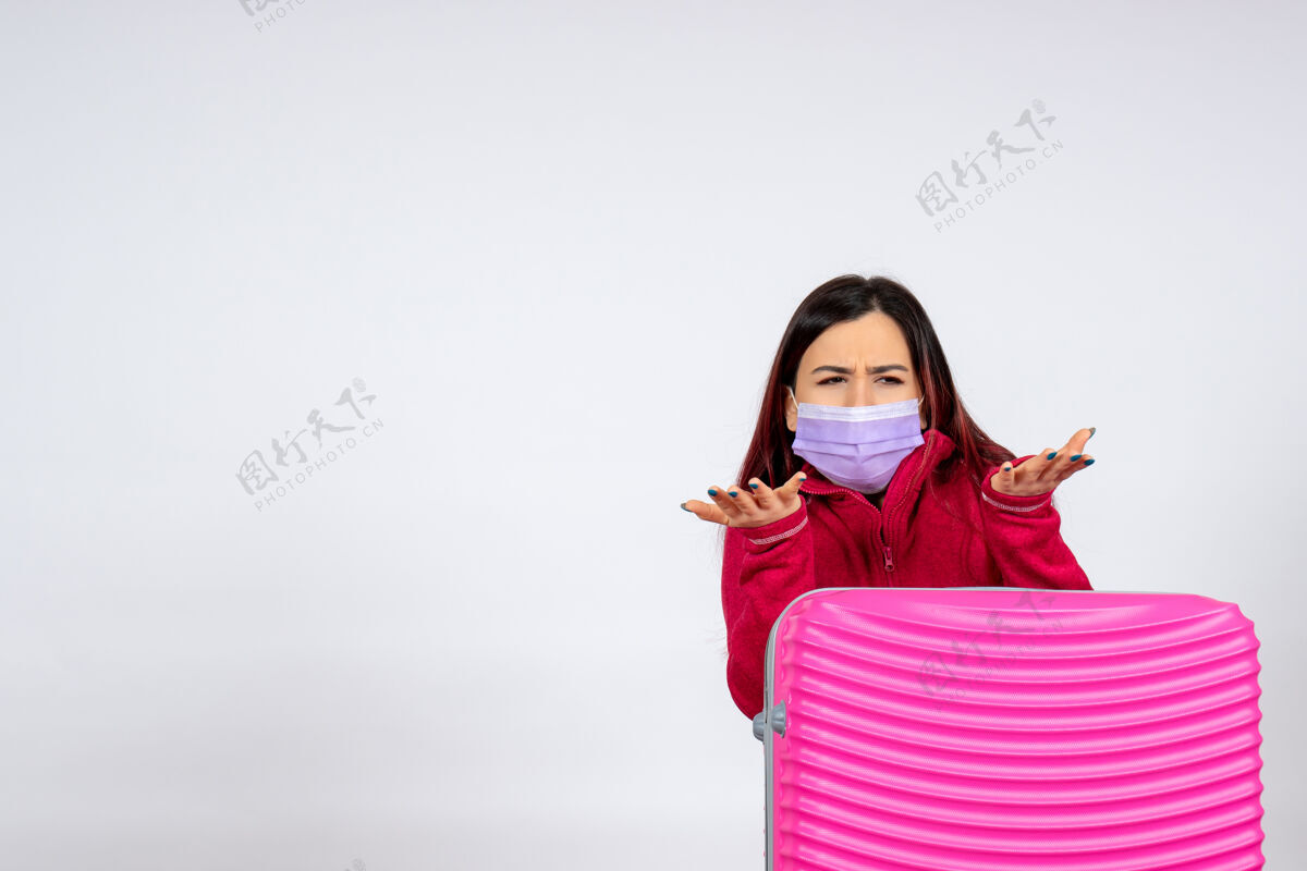 颜色正面图年轻女性带着粉红色的袋子在白墙面具上放假病毒呈白色大流行成人病毒游客