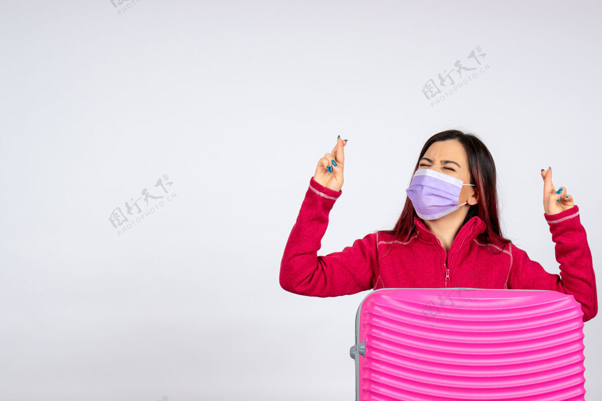 女人正面图年轻女性带着粉色袋子在白墙上戴着口罩度假大流行病毒冠状病毒-彩色旅行女人风景病毒流行病