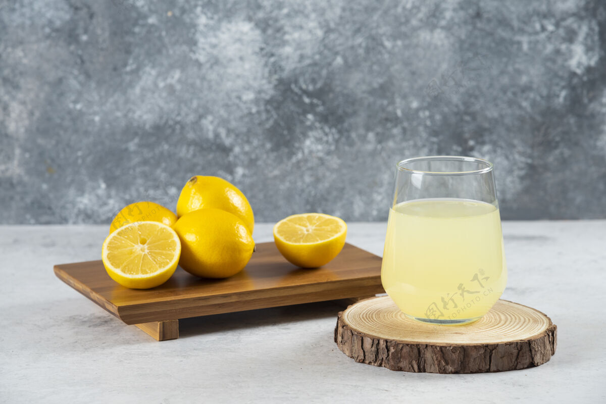 水果在木板上放一杯新鲜的柠檬汁玻璃柠檬冷