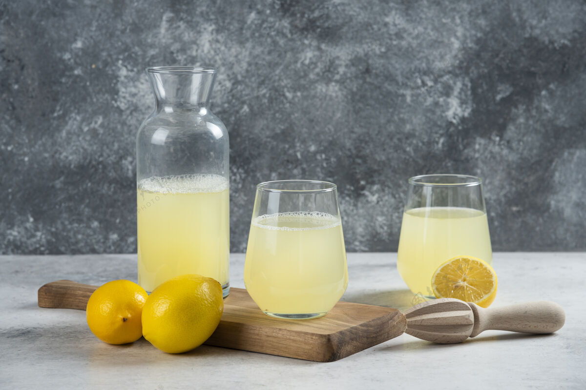 美味两杯柠檬汁和一个装在木板上的罐子自然冷提神