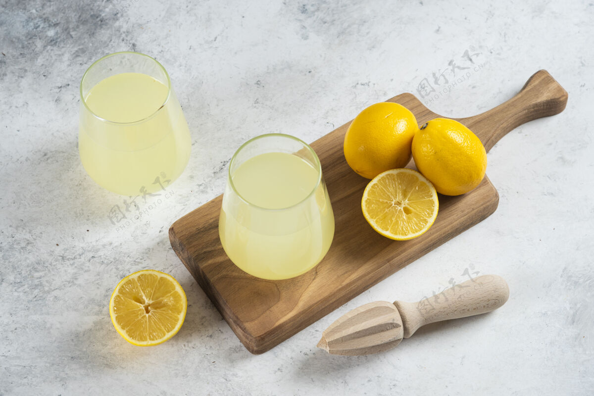 新鲜两杯柠檬水和木铰刀桌子美味柠檬水