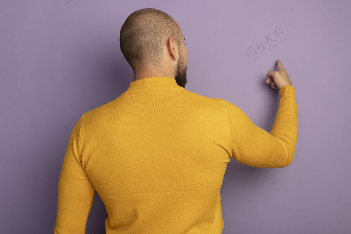 立场站在后面的视线年轻帅哥指着后面孤立的紫色墙壁和复制空间观点观点男人
