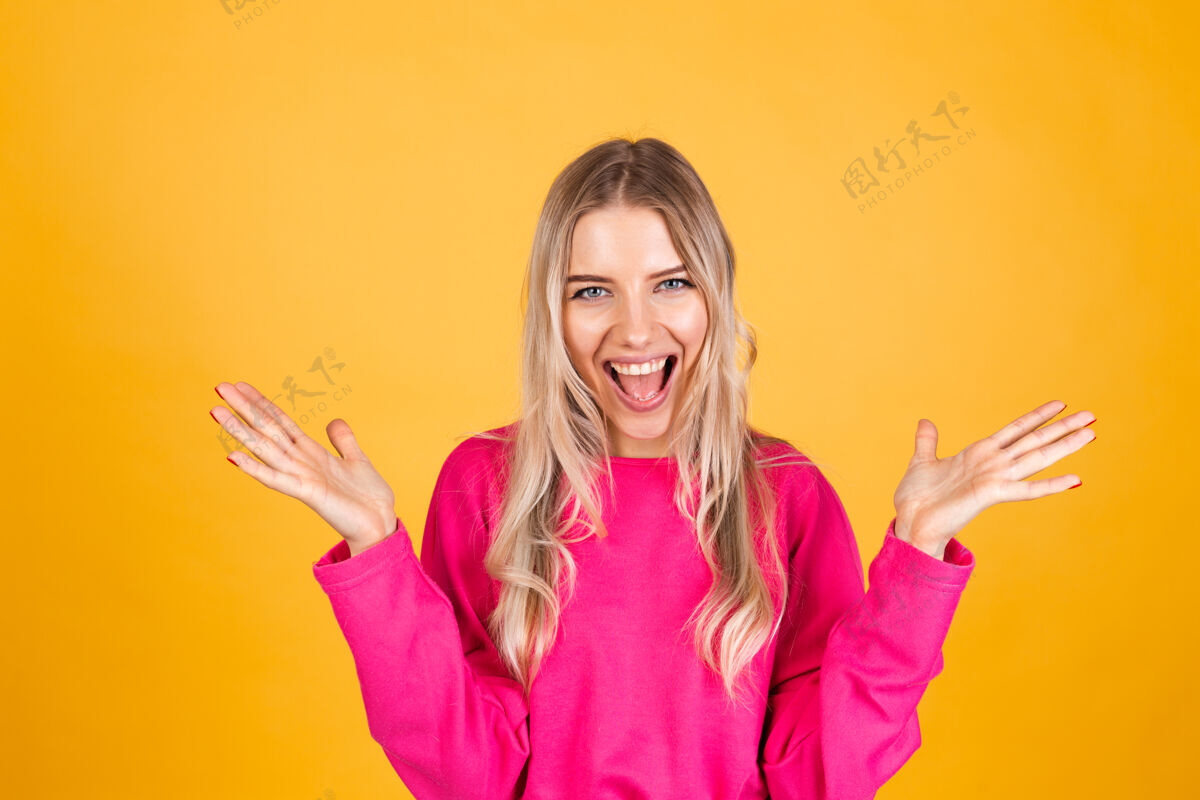 兴奋黄色墙上穿粉红色上衣的漂亮欧洲女人人少女人