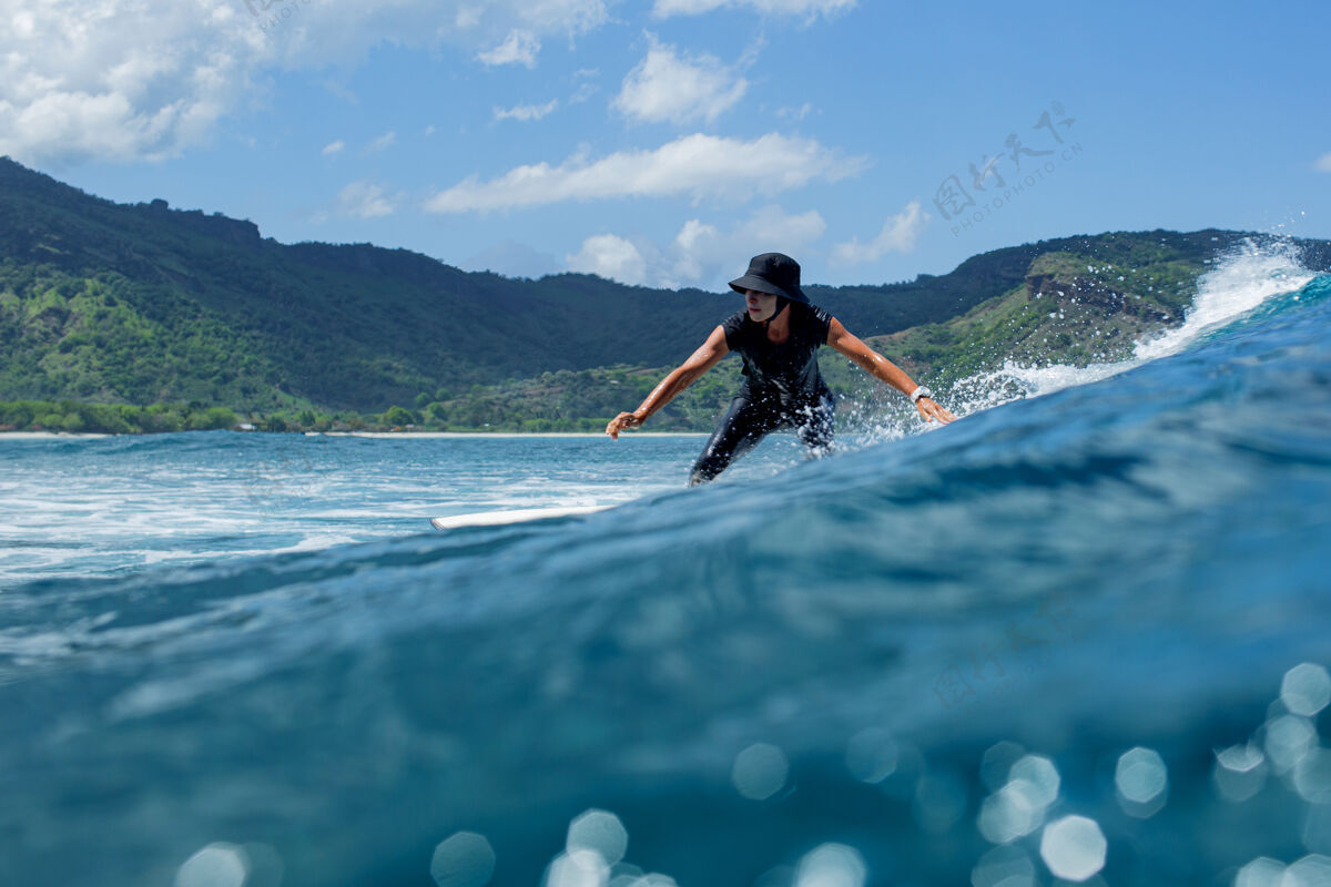 热带在蓝色波浪上冲浪运动冲浪者运动员