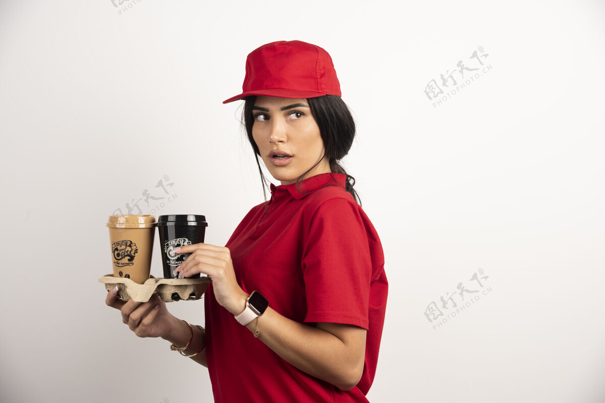 外卖带咖啡杯的送货员在白色背景上摆姿势高质量照片工人黑发咖啡