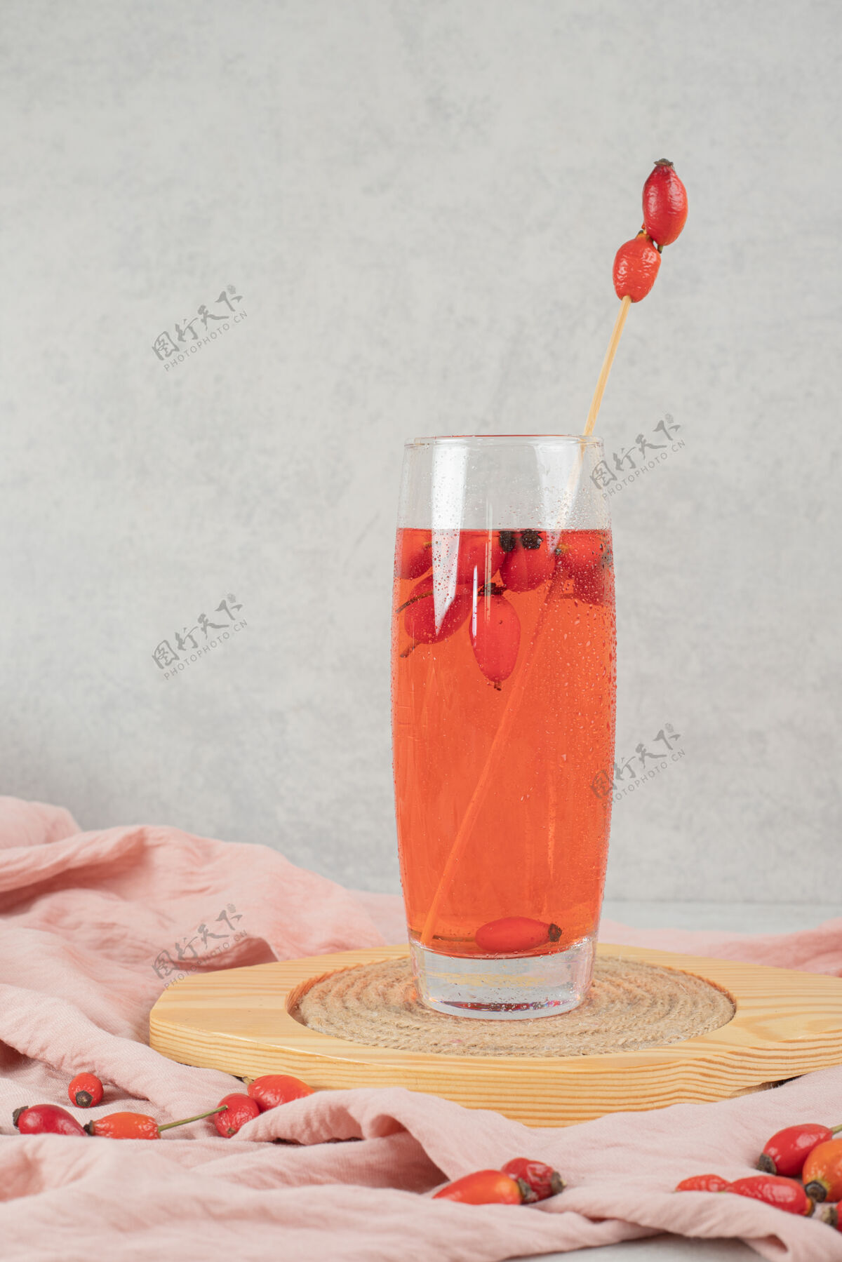 液体一杯新鲜柠檬水加玫瑰果放在木盘上果汁切片美味