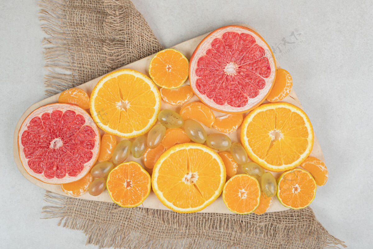 成熟在木板上放一堆柑橘片切块粗麻布葡萄