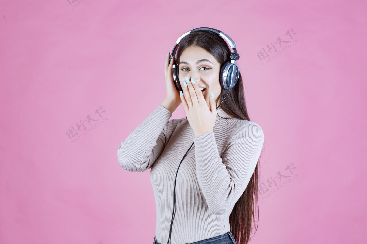 象征戴着耳机的女孩在听音乐 展示她的快乐快乐成人服装