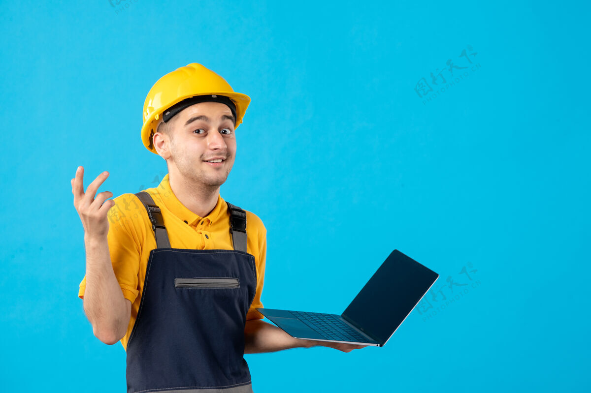 工程师前视图穿着制服的男工人带着蓝色笔记本电脑工作承包商男人