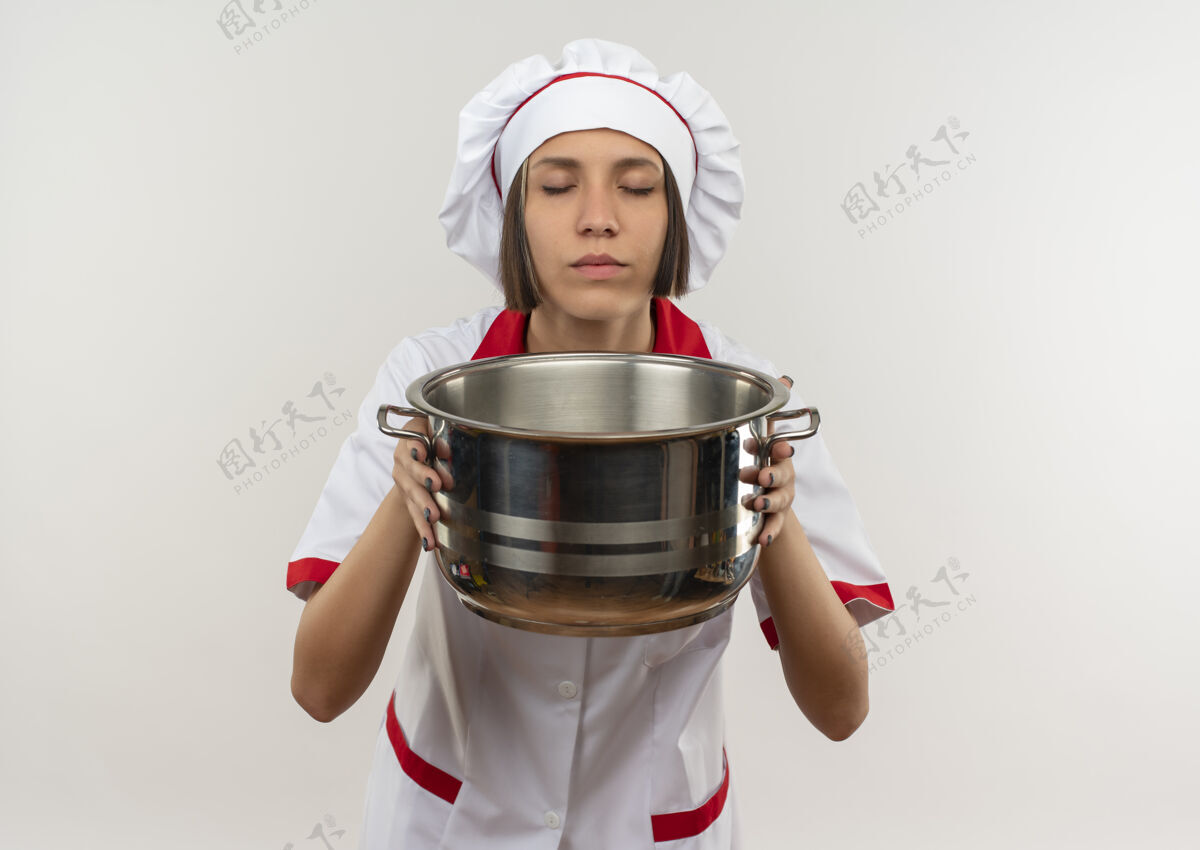 女身着厨师制服的年轻女厨师手持嗅壶 双眼紧闭 背景为白色 留有复印空间烹饪封闭持有
