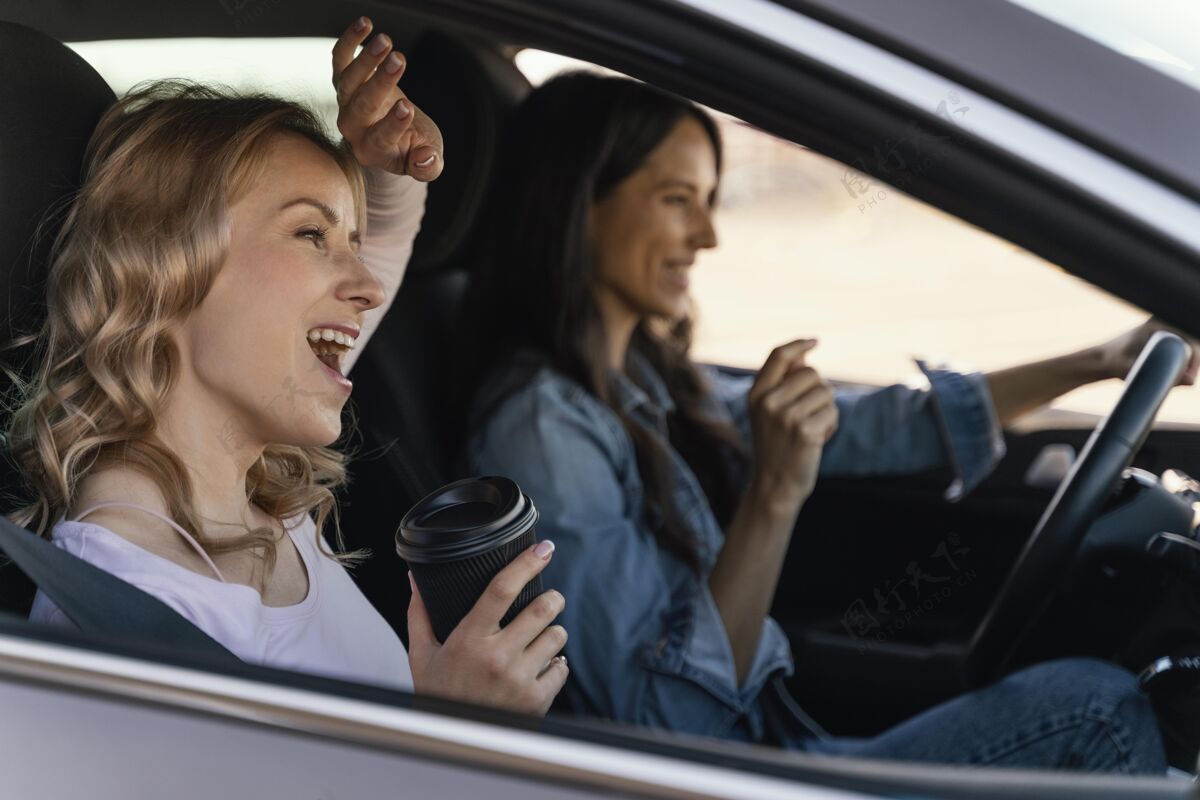 女人女孩们在车里玩得很开心成年人汽车车