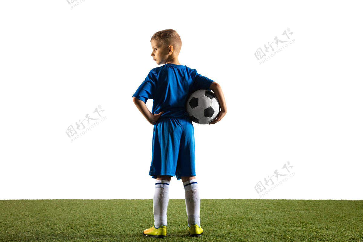 游戏穿运动服的足球或足球运动员站着拿着球像一个胜利者 最好的前锋或守门员站在白墙上适合在比赛中扮演男孩的动作 动作 动作动态草地分数