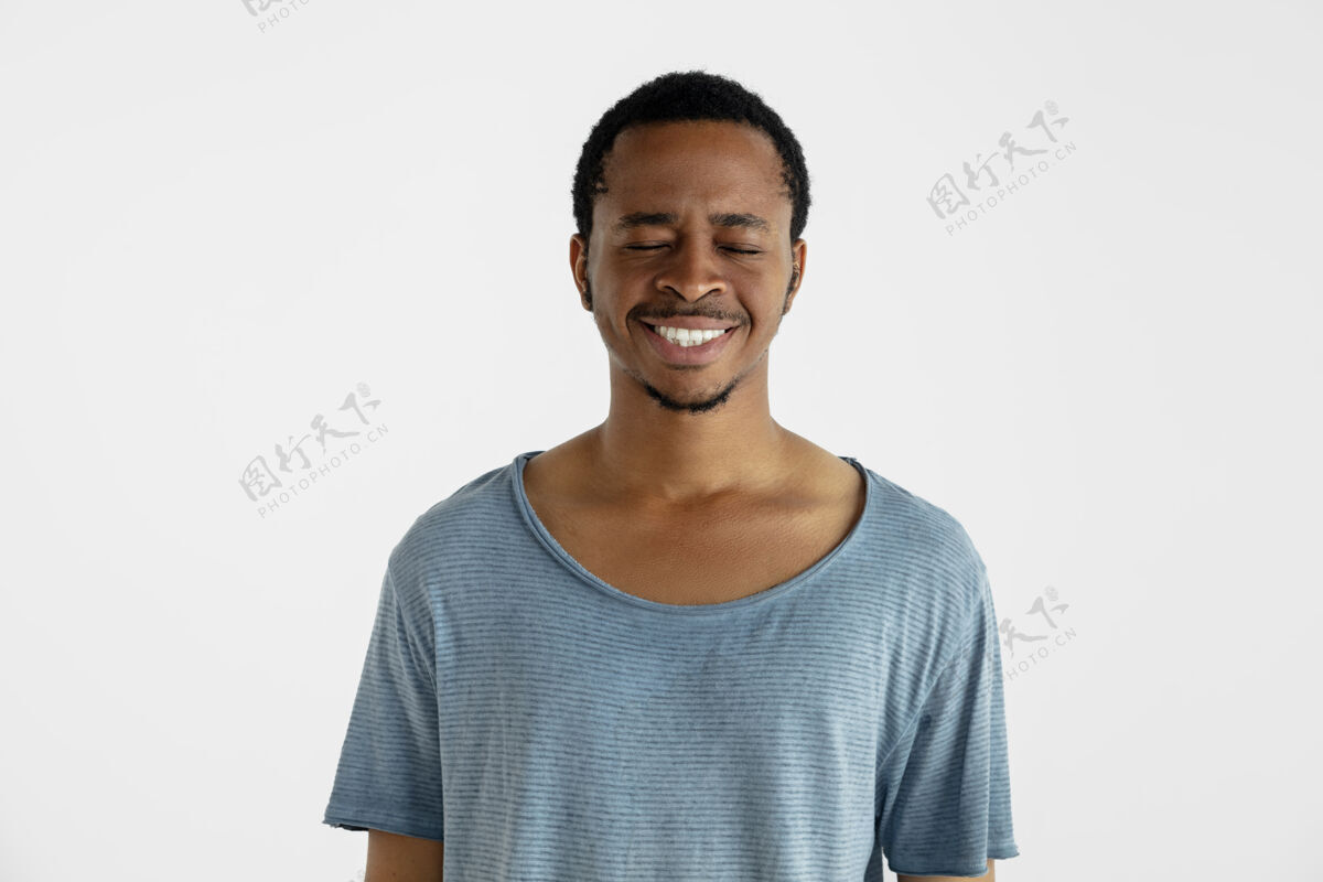 男性美丽的男性半身像隔离在白色的墙上年轻的情感非洲裔美国人在蓝色衬衫面部表情 人类的情感 广告概念笑声 疯狂的快乐快乐男人黑发