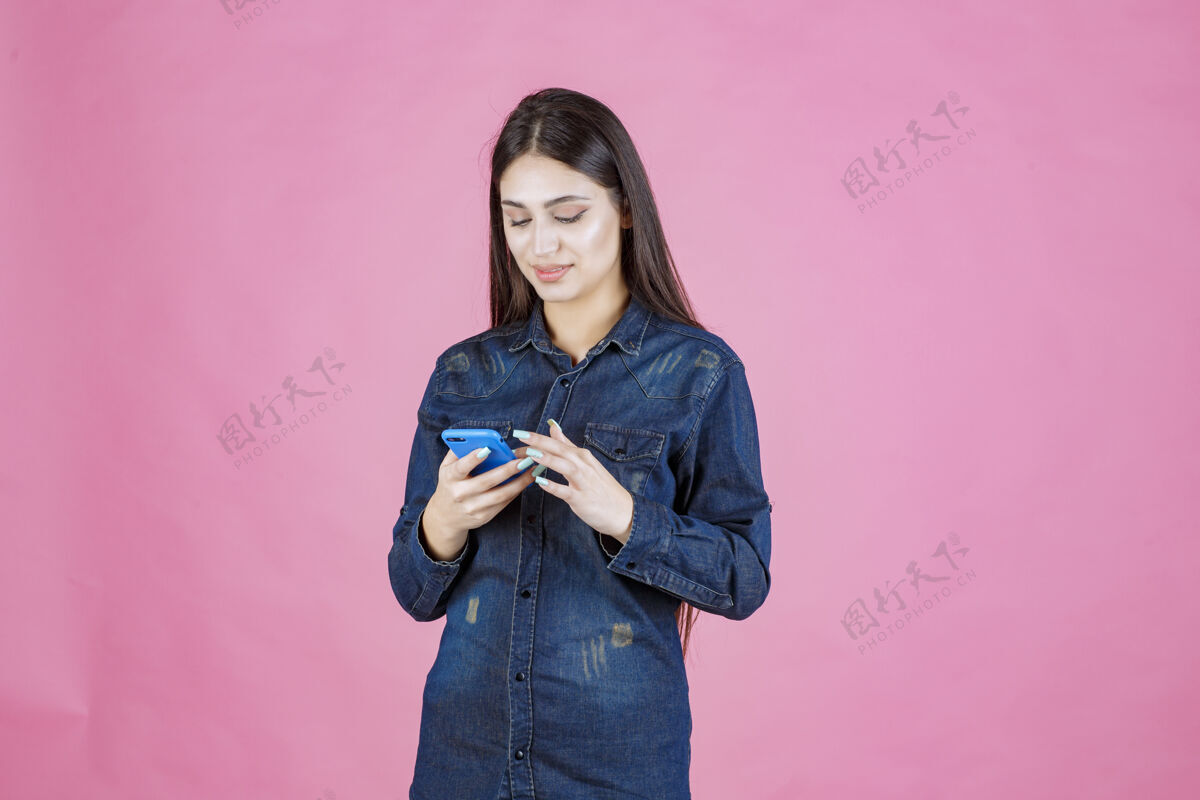 服装穿着牛仔衬衫的女孩在智能手机前聊天成人设备音频