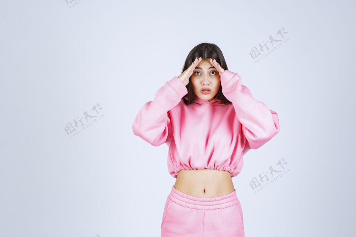 成人穿粉红色睡衣的女孩看起来既困惑又怀疑新的女性服装