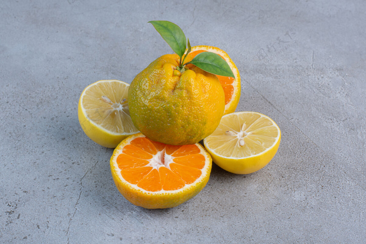 柠檬整个橘子放在柠檬上 橘子片放在大理石背景上美味美味天然