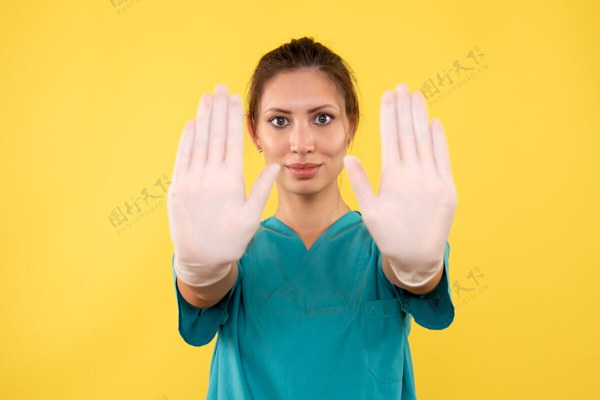 前面前视图黄色背景上戴手套的女医生女医生成人病毒