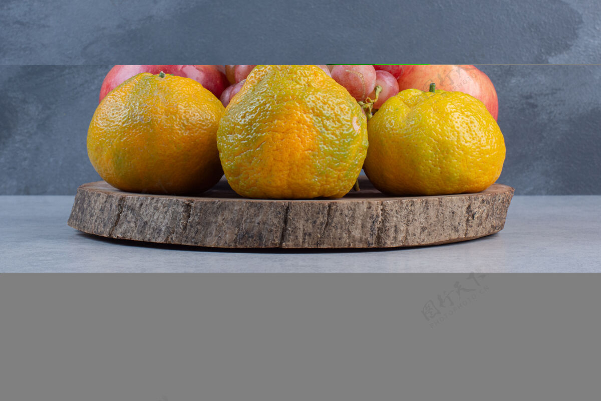 木头新鲜的有机水果放在木板上橘子 红葡萄和苹果克莱门汀许多葡萄
