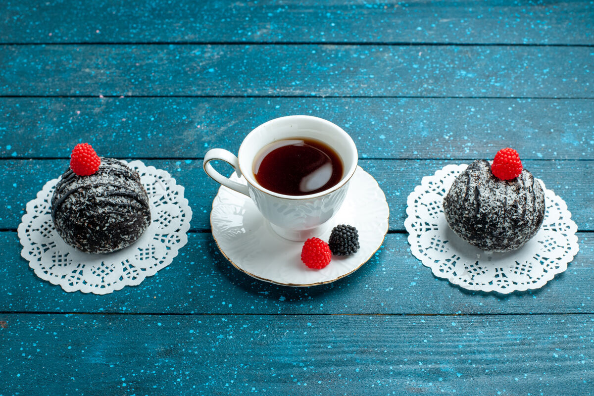 球前视图美味的巧克力球和一杯茶在蓝色的乡村书桌上茶蛋糕饼干饼干甜蛋糕桌子茶