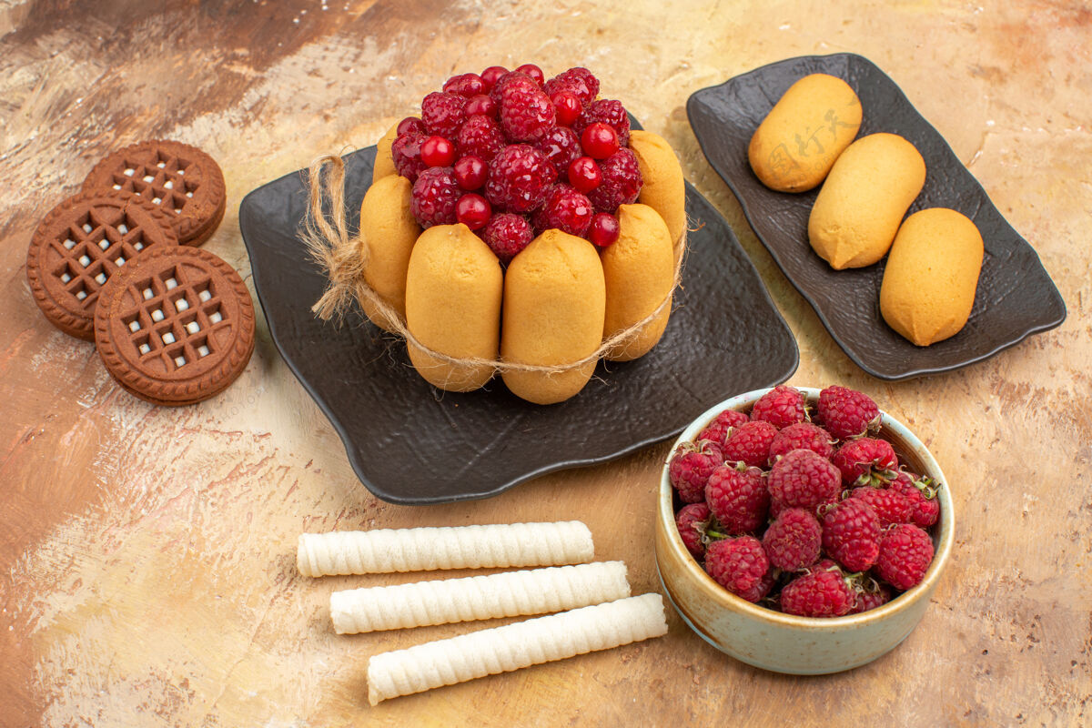 新鲜礼品蛋糕和饼干放在棕色盘子上水果放在混合颜色的桌子旁盘子可食用水果壁板
