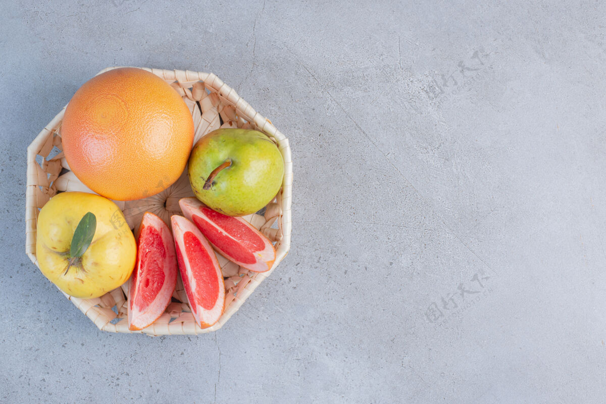 美味一小包水果放在大理石背景的白色篮子里新鲜饮食营养