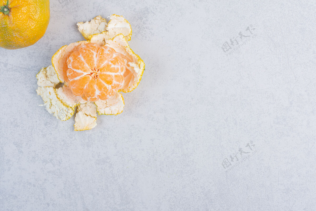 柑橘在灰色背景上剥皮和整个橘子组新鲜灰色