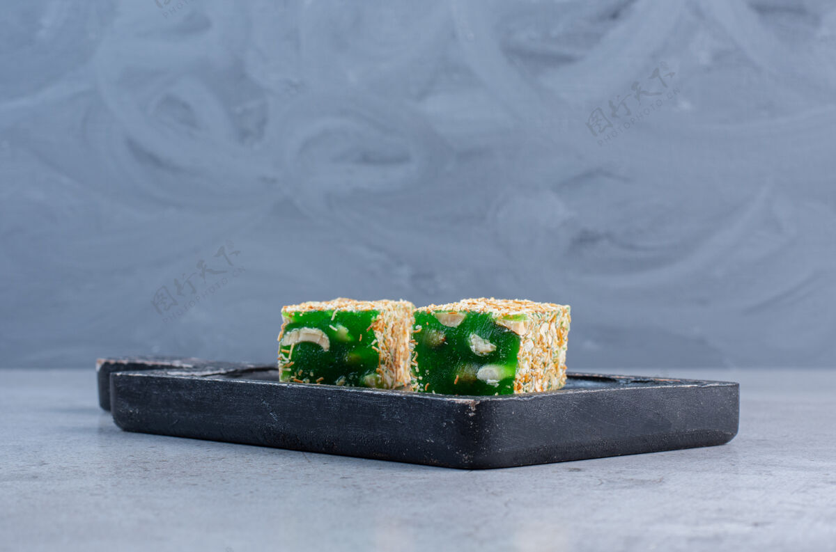 风味绿色土耳其语愉快的大理石背景上的一个小董事会颜色美味甜点
