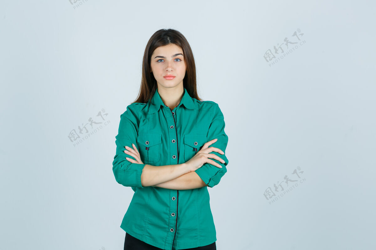 抑郁身着绿色衬衫的美丽年轻女士双臂交叉 表情严肃 正面照年轻问题自信