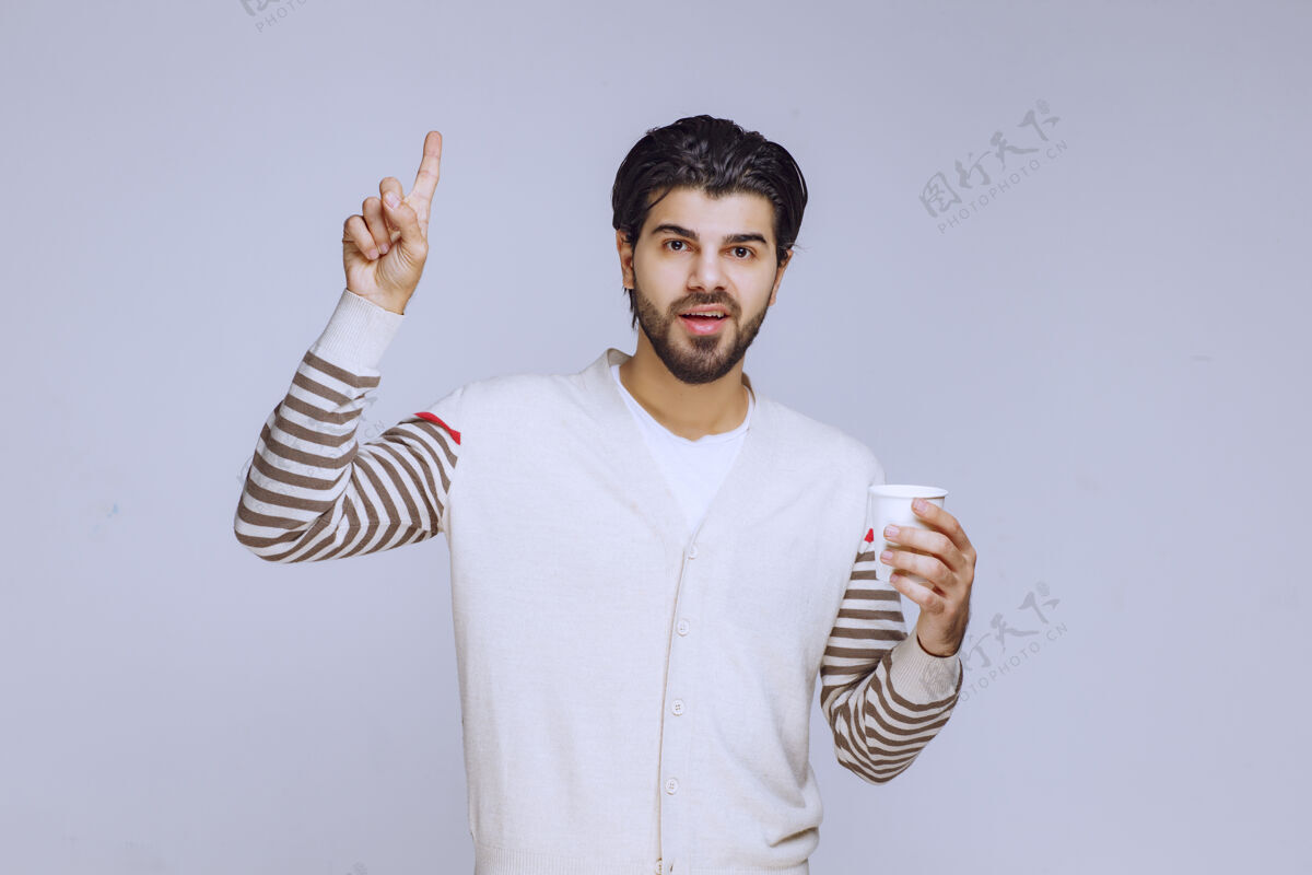 人类一个穿着白衬衫的男人拿着一个咖啡杯享受着它员工晋升员工
