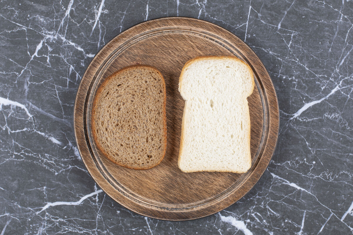 风味白黑面包在木板上 大理石表面美味面包食材