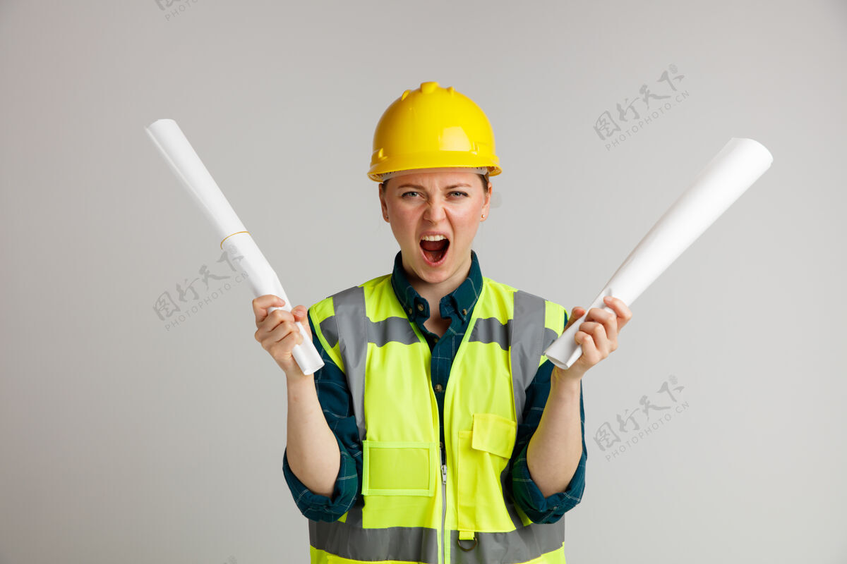 建筑紧张的年轻女建筑工人戴着安全帽和安全背心拿着文件尖叫持有年轻纸张