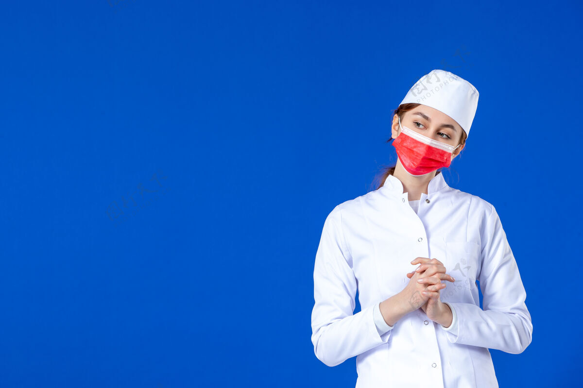 医药身穿医疗服的年轻护士的正视图 红色面罩 蓝色外衣疾病喜剧演员