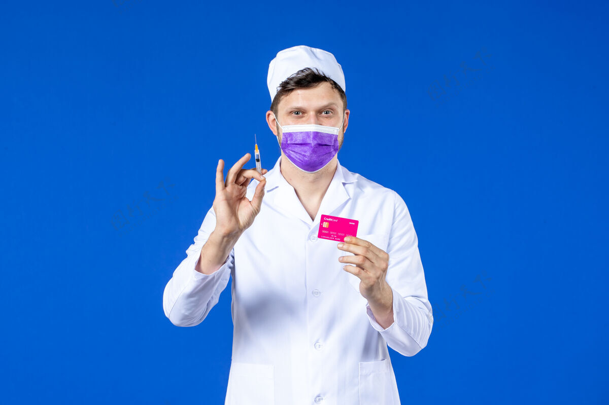 医院前视图中的男医生穿着医疗服和紫色面罩持有注射和信用卡在蓝色流行病金钱信贷