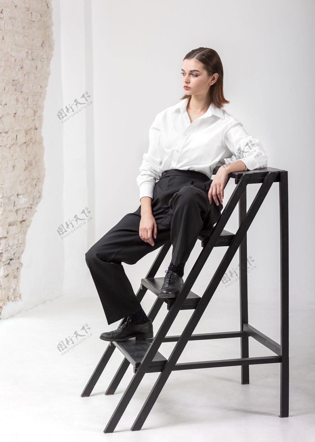 衬衫优雅的女模特穿着夹克在楼梯上摆姿势新的女性概念明亮的背景时尚美丽
