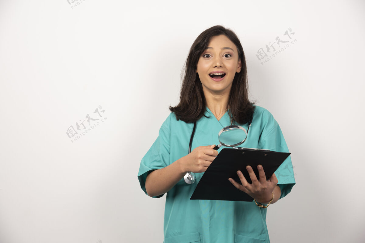 工作快乐的医生与剪贴板和放大镜上的白色背景微笑制服工人