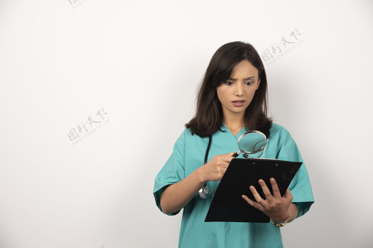 医疗女医生在白色背景上用放大镜看结果放大镜医生工作