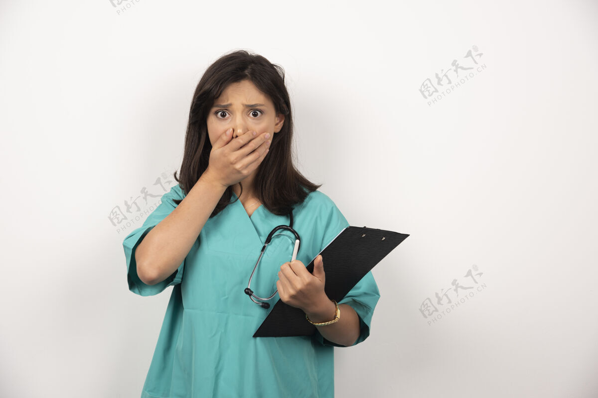 肖像医生用听诊器和剪贴板把她的嘴盖在白色的背景上诊所医生剪贴板