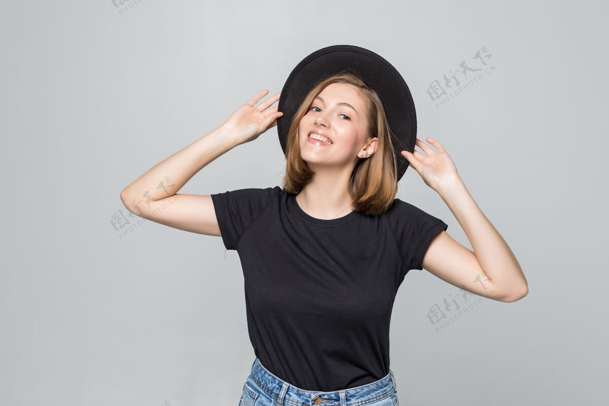 西班牙裔漂亮的年轻女子戴着黑色软帽 在白色的地板上摆着孤立的姿势拉丁华丽休闲