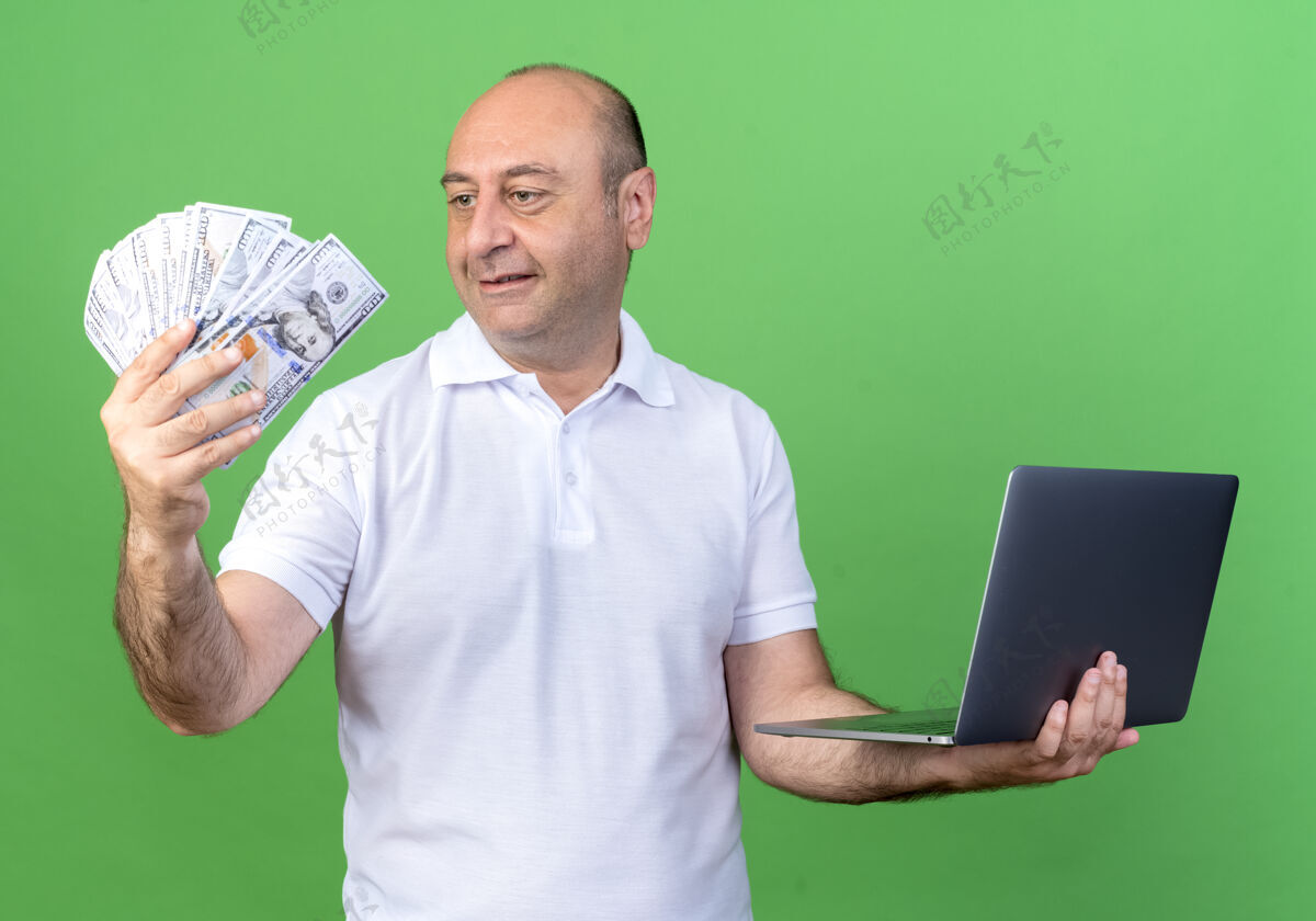 控股一个不经意的成熟男人拿着笔记本电脑 看着手里的现金手现金休闲