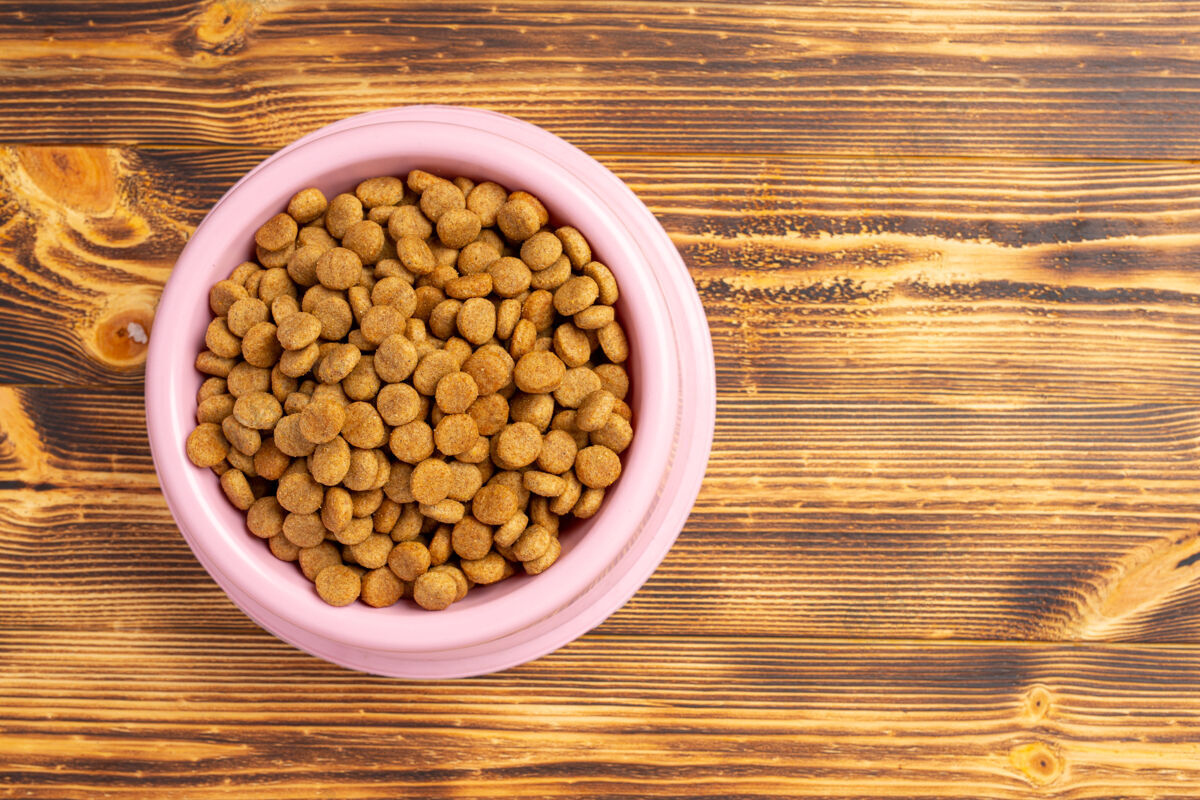 堆把狗粮放在碗里 放在深色的木头表面上堆食物营养