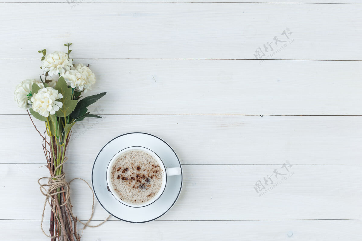 卡布奇诺一组花和咖啡放在一个木制背景的杯子里顶视图木头拿铁套装