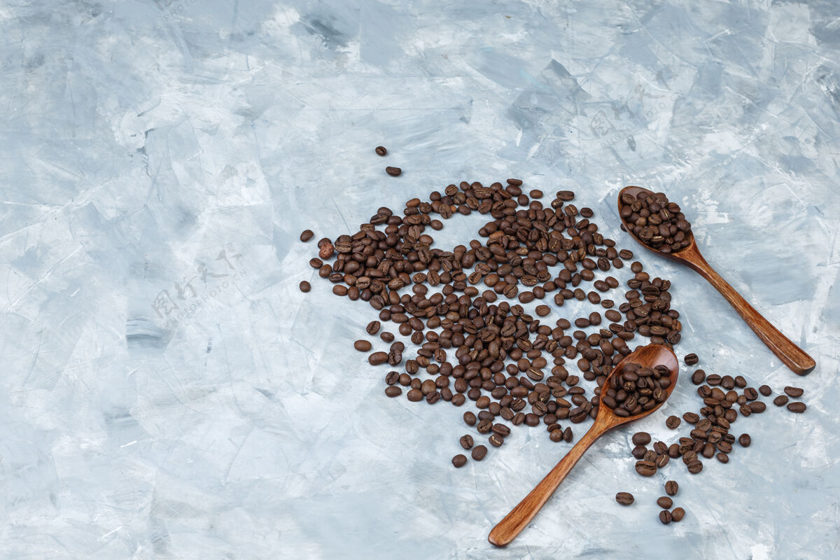 水平把咖啡豆平铺在灰色灰泥背景上的木勺里水平能量咖啡新鲜的