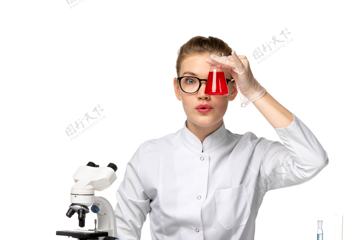 前面前视图穿着白色医疗服的女医生正在用白色地板上的解决方案解决病毒性疾病的健康问题地板眼镜工作