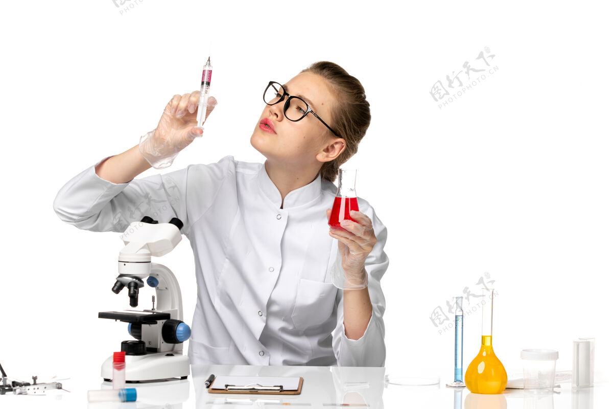病毒前视图穿着白色医疗服的女医生在白色办公桌上用解决方案工作办公室女医生疾病