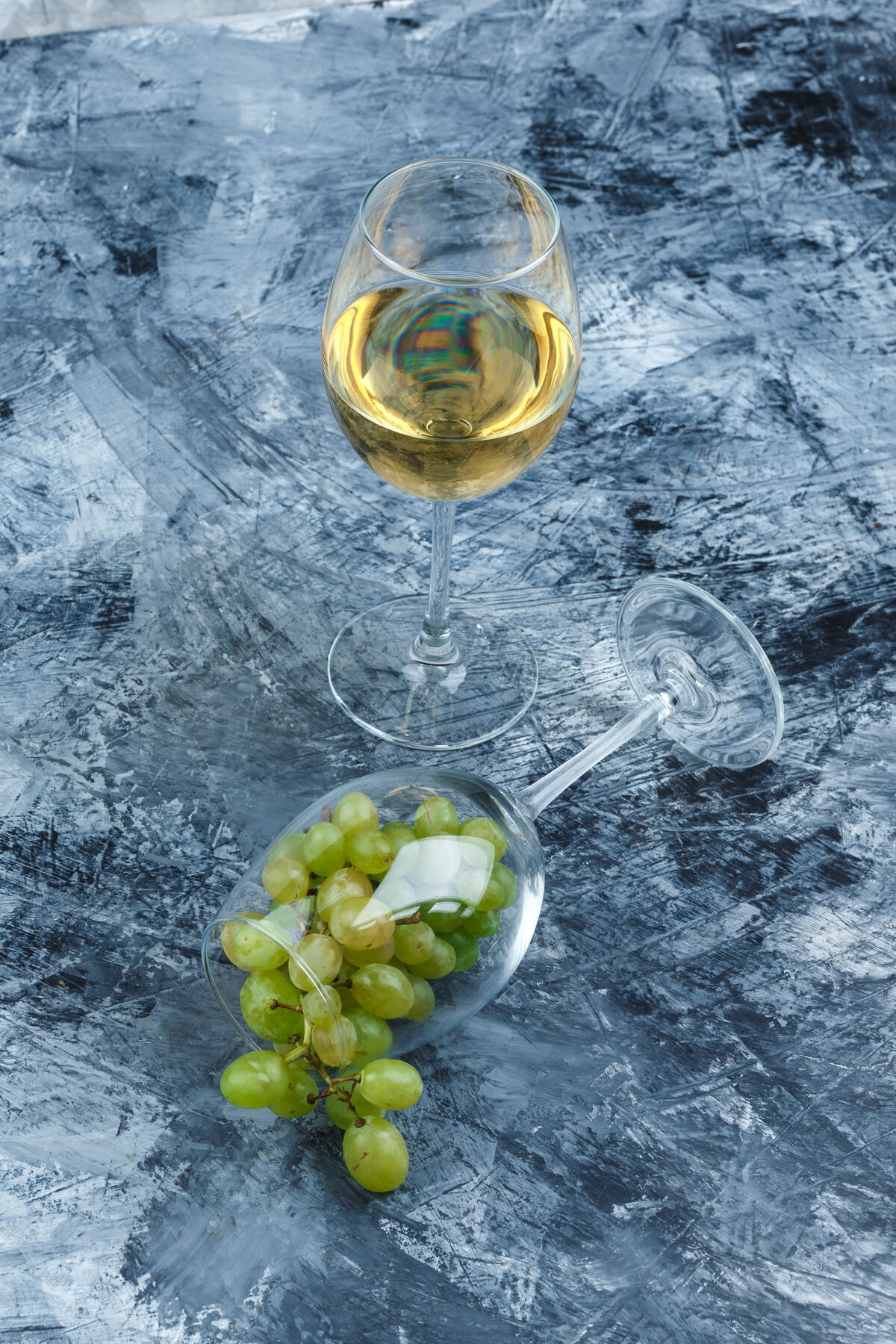 健康在深蓝色大理石背景上 用一杯威士忌和一杯白葡萄合起来垂直秋天浆果玻璃