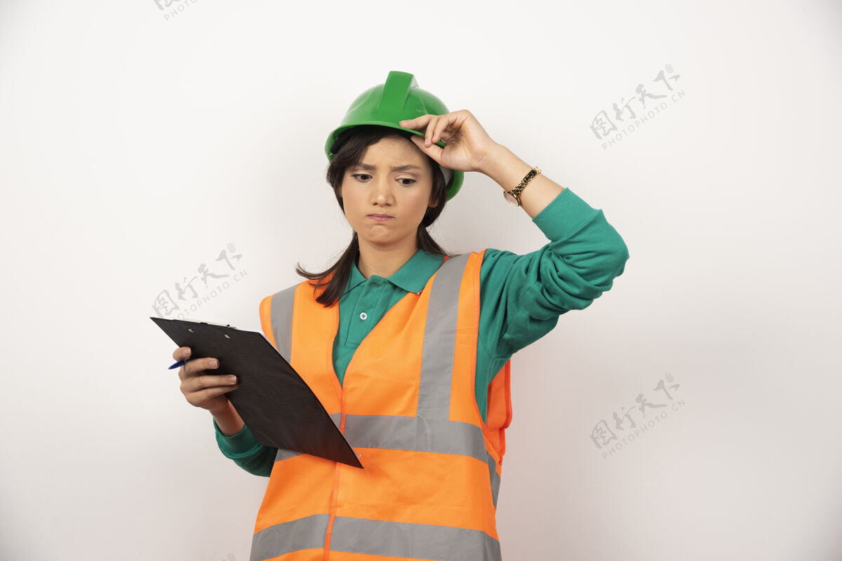 工人在白色背景上用剪贴板搅乱穿着制服的女工业工程师肖像个人女性