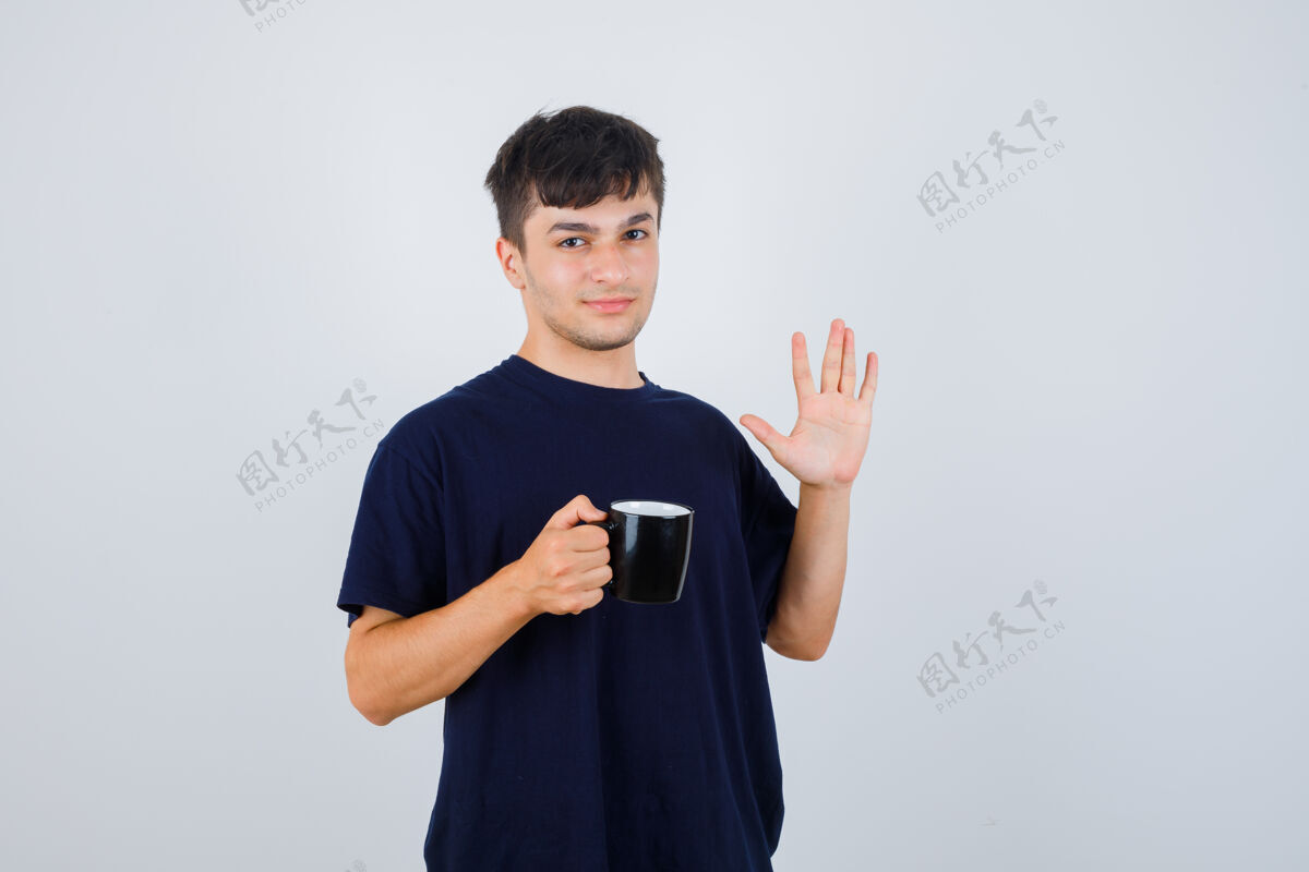 男性身穿黑色t恤的年轻人捧着一杯茶 露出掌心 神情自信 俯瞰前方衣服表情自信